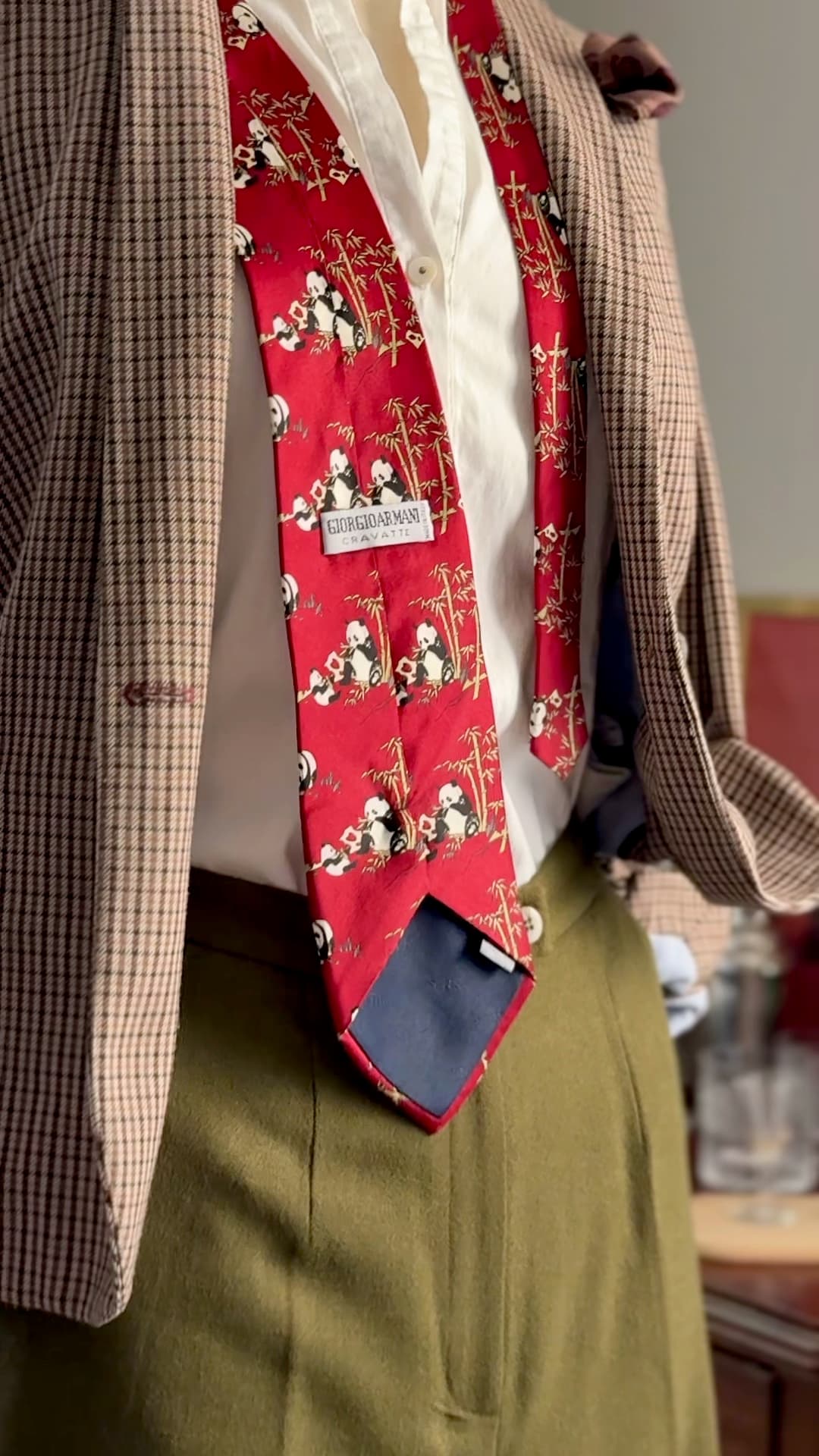 Vintage Giorgio Armani Cravatte tie in lacquer red, printed with pandas in a bamboo grove, styled over a white shirt and houndstooth jacket.