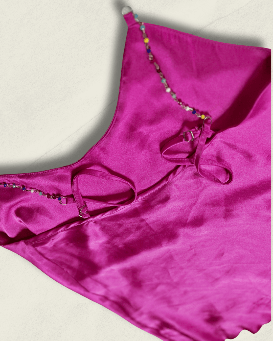 Y2K fuchsia Nicole Miller bias-cut silk camisole with multicolor hand-beaded straps and a draped neckline, shown flat.