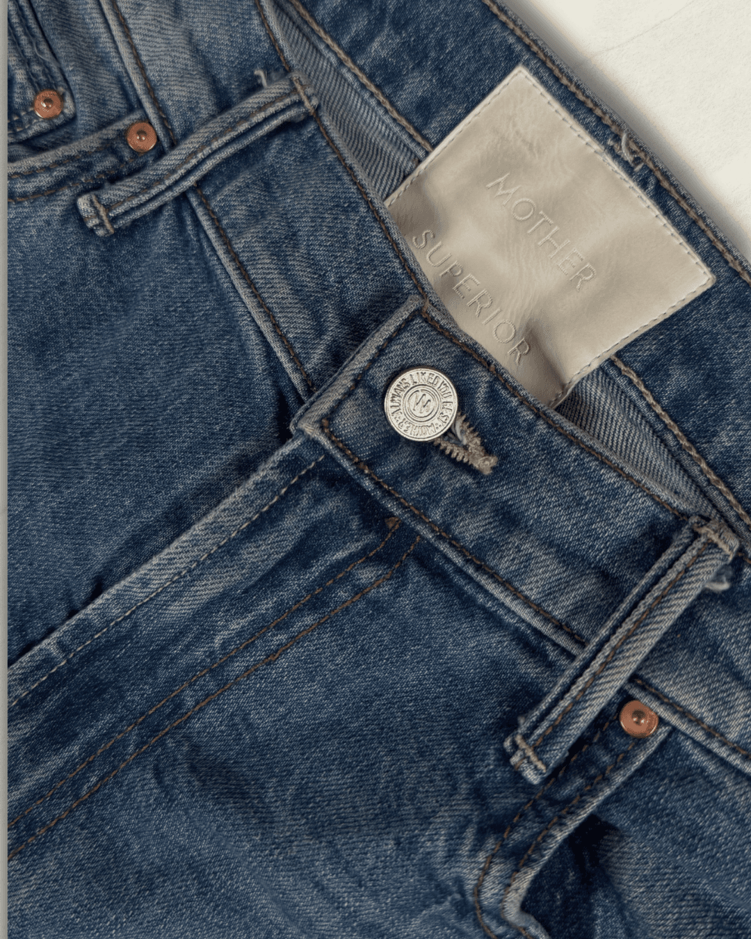 MOTHER Mid-Rise Maven Ankle wide-leg jean in medium blue denim with a raw frayed hem and crown-stitch back pockets, shown flat.