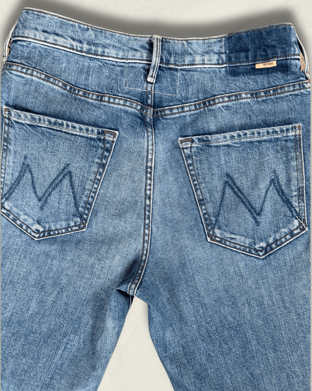 MOTHER Mid-Rise Maven Ankle wide-leg jean in medium blue denim with a raw frayed hem and crown-stitch back pockets, shown flat.