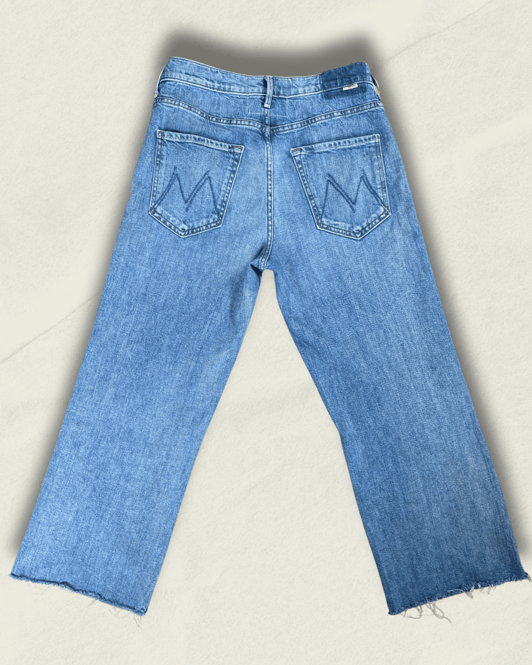 MOTHER Mid-Rise Maven Ankle wide-leg jean in medium blue denim with a raw frayed hem and crown-stitch back pockets, shown flat.