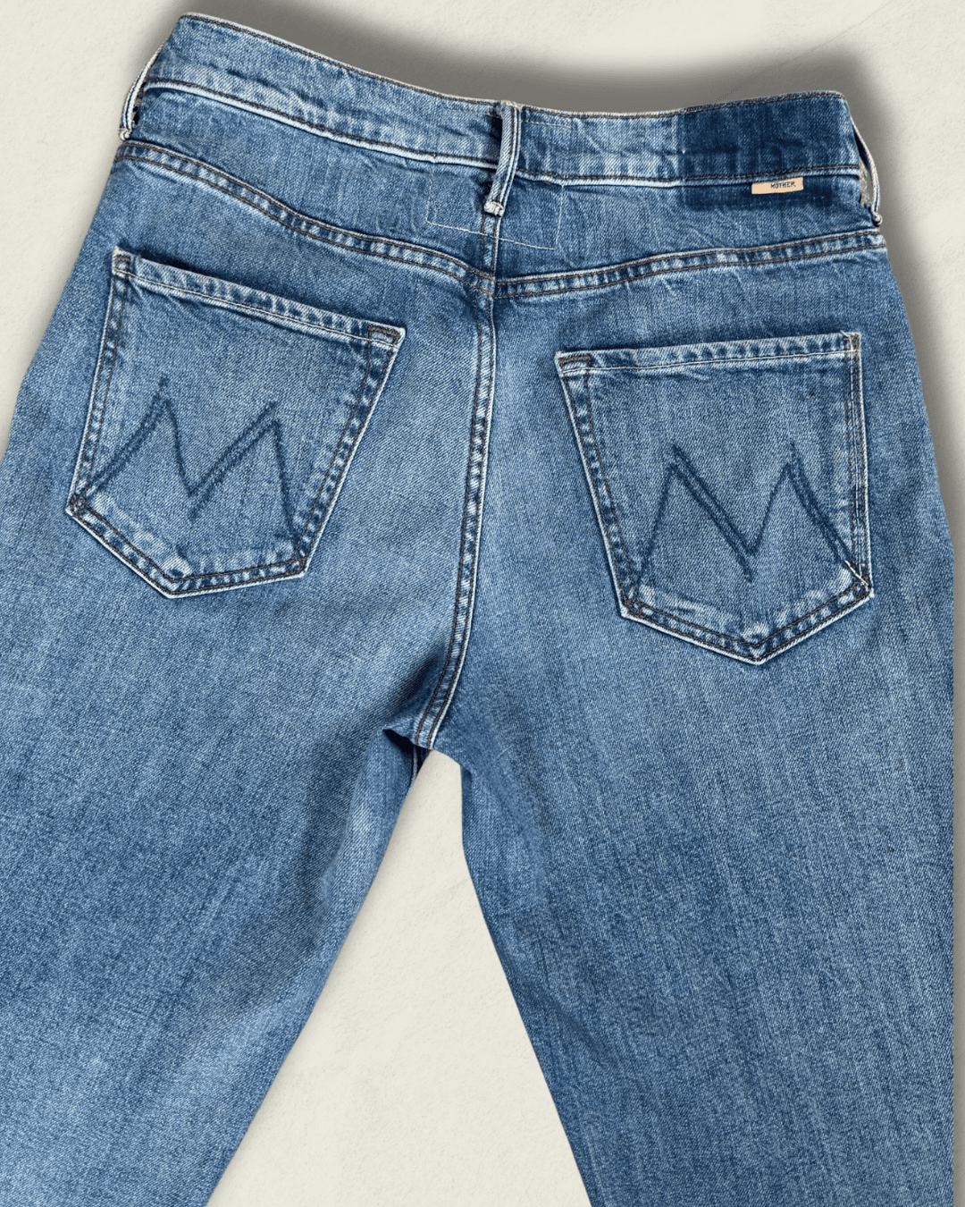 MOTHER Mid-Rise Maven Ankle wide-leg jean in medium blue denim with a raw frayed hem and crown-stitch back pockets, shown flat.
