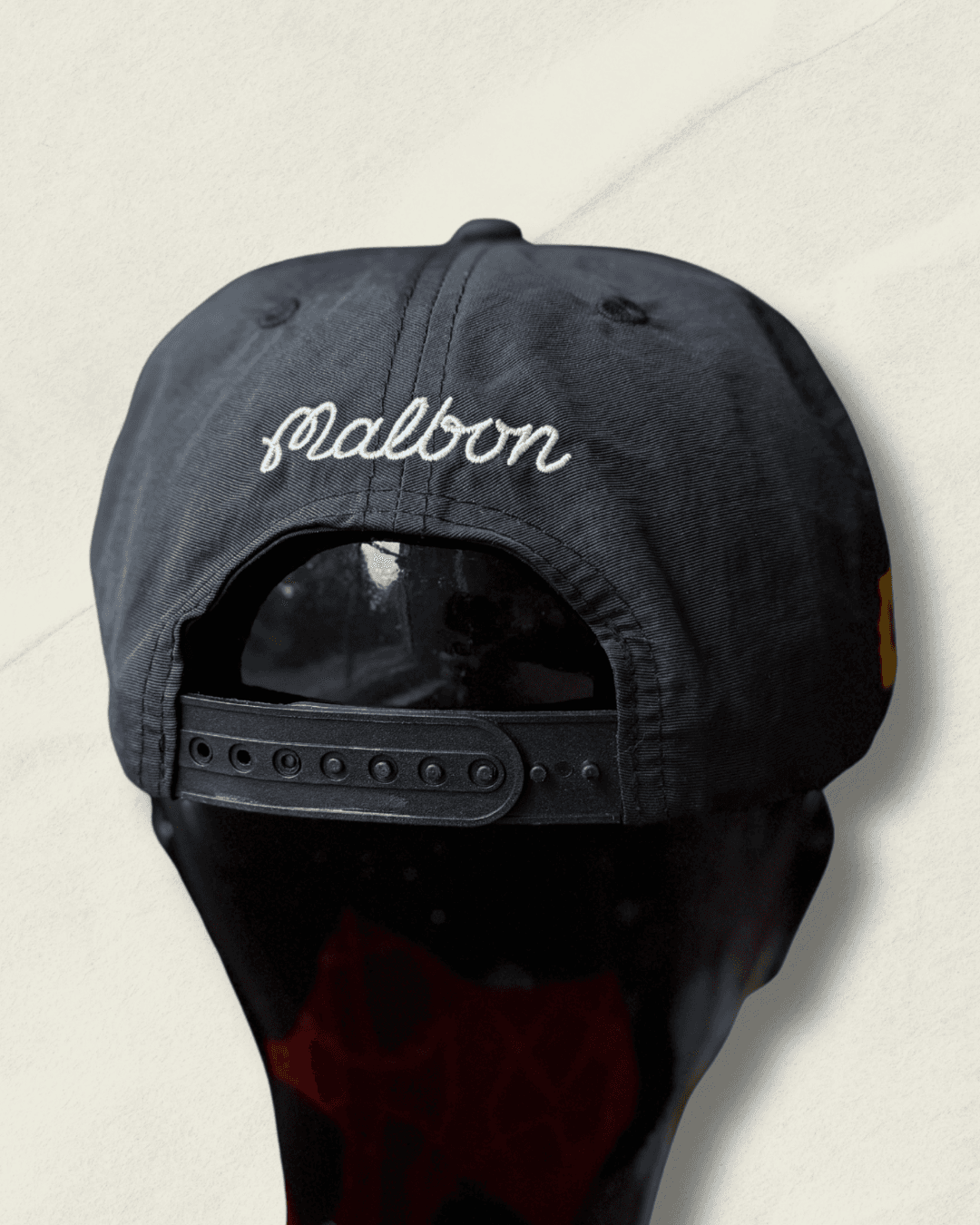 Black Malbon Golf x Motive x DeWalt nylon rope golf hat, front view with raised white motive embroidery, white rope, and yellow DeWalt patches on the sides.