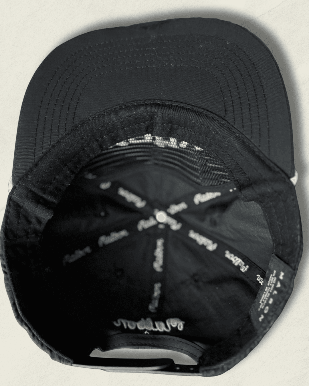 Black Malbon Golf x Motive x DeWalt nylon rope golf hat, front view with raised white motive embroidery, white rope, and yellow DeWalt patches on the sides.
