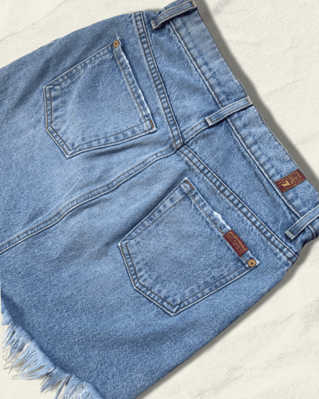 7 For All Mankind light-wash distressed denim mini skirt with raw fringed asymmetric hem, size 25