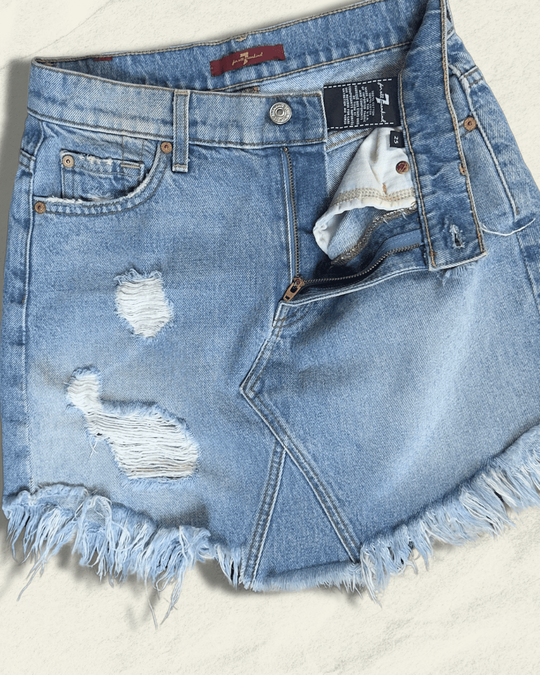 7 For All Mankind light-wash distressed denim mini skirt with raw fringed asymmetric hem, size 25