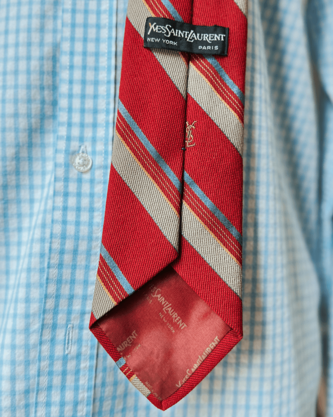 Vintage Yves Saint Laurent crimson repp-stripe tie with sand and sky-blue diagonal stripes, styled over a blue gingham shirt and houndstooth jacket.