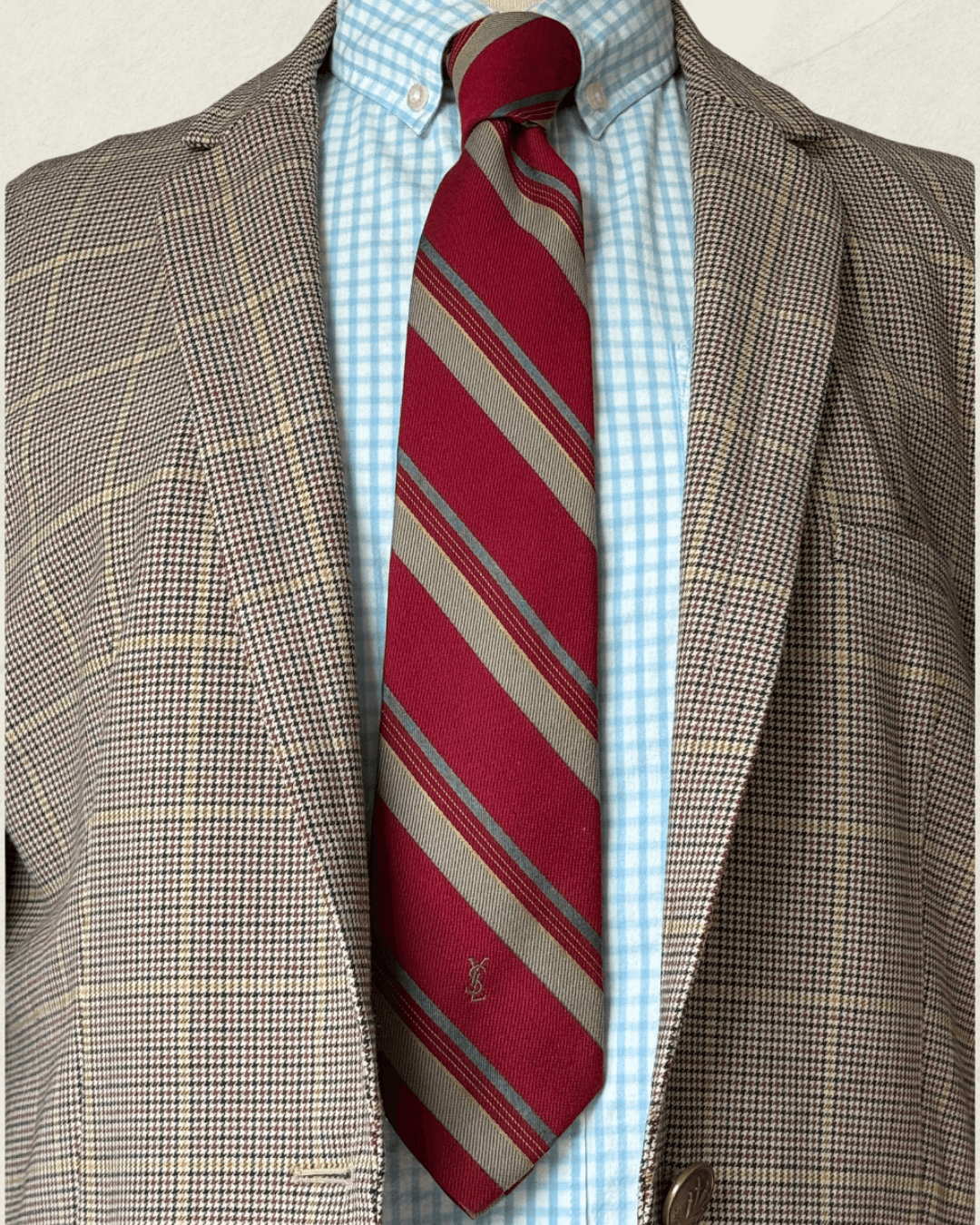 Vintage Yves Saint Laurent crimson repp-stripe tie with sand and sky-blue diagonal stripes, styled over a blue gingham shirt and houndstooth jacket.