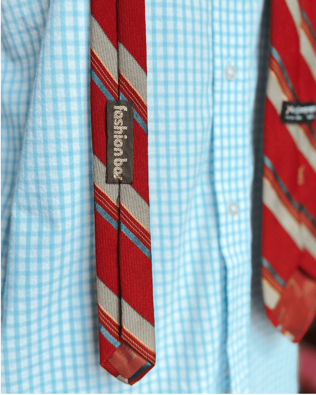 Vintage Yves Saint Laurent crimson repp-stripe tie with sand and sky-blue diagonal stripes, styled over a blue gingham shirt and houndstooth jacket.