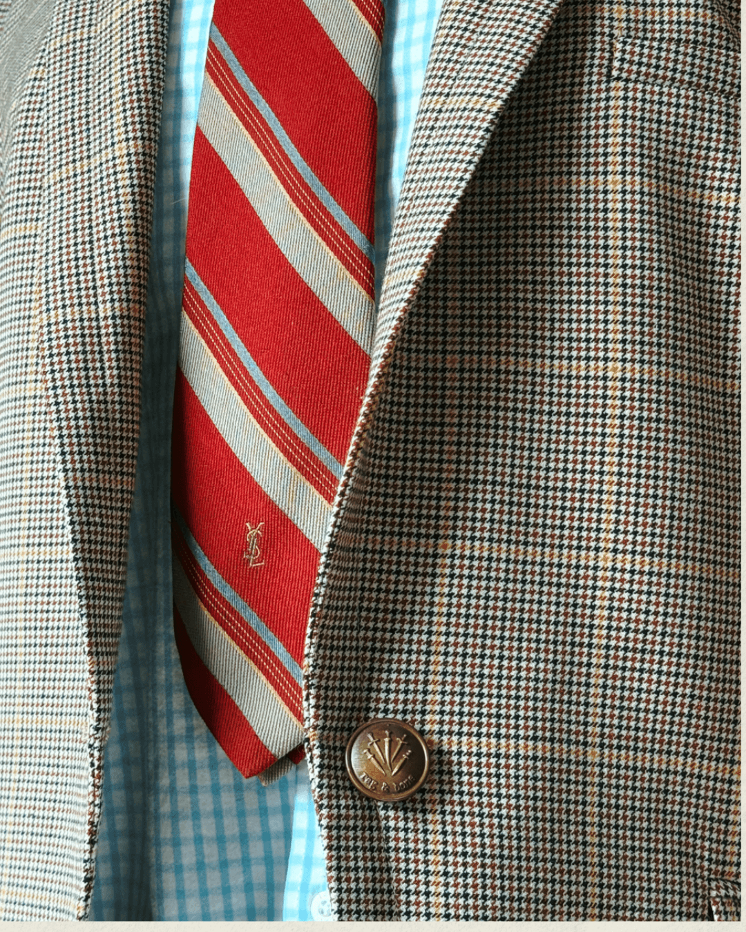 Vintage Yves Saint Laurent crimson repp-stripe tie with sand and sky-blue diagonal stripes, styled over a blue gingham shirt and houndstooth jacket.